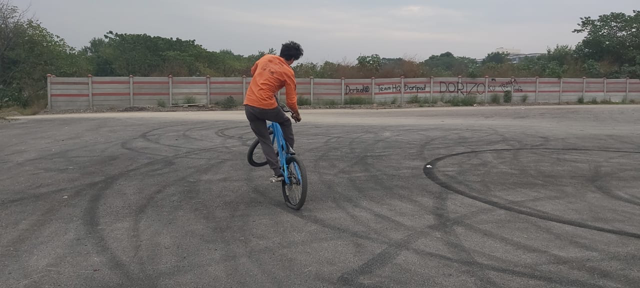 Ein junger Mann fährt BMX Fahrrad auf Asphalt